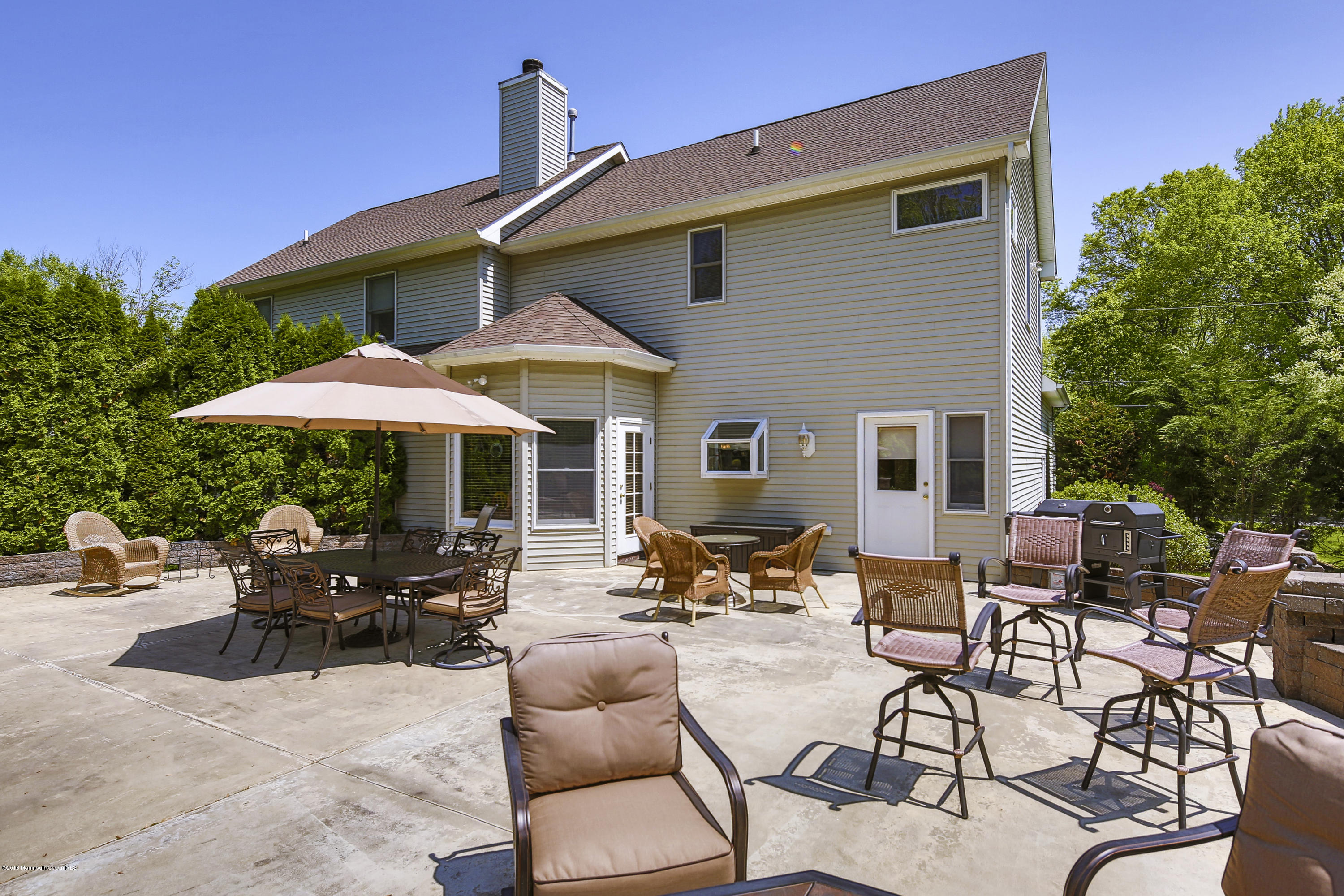 55 Spring Road Clarksburg, NJ 08510 - Photo 35 of 44 a patio with a table and chairs under an umbrella