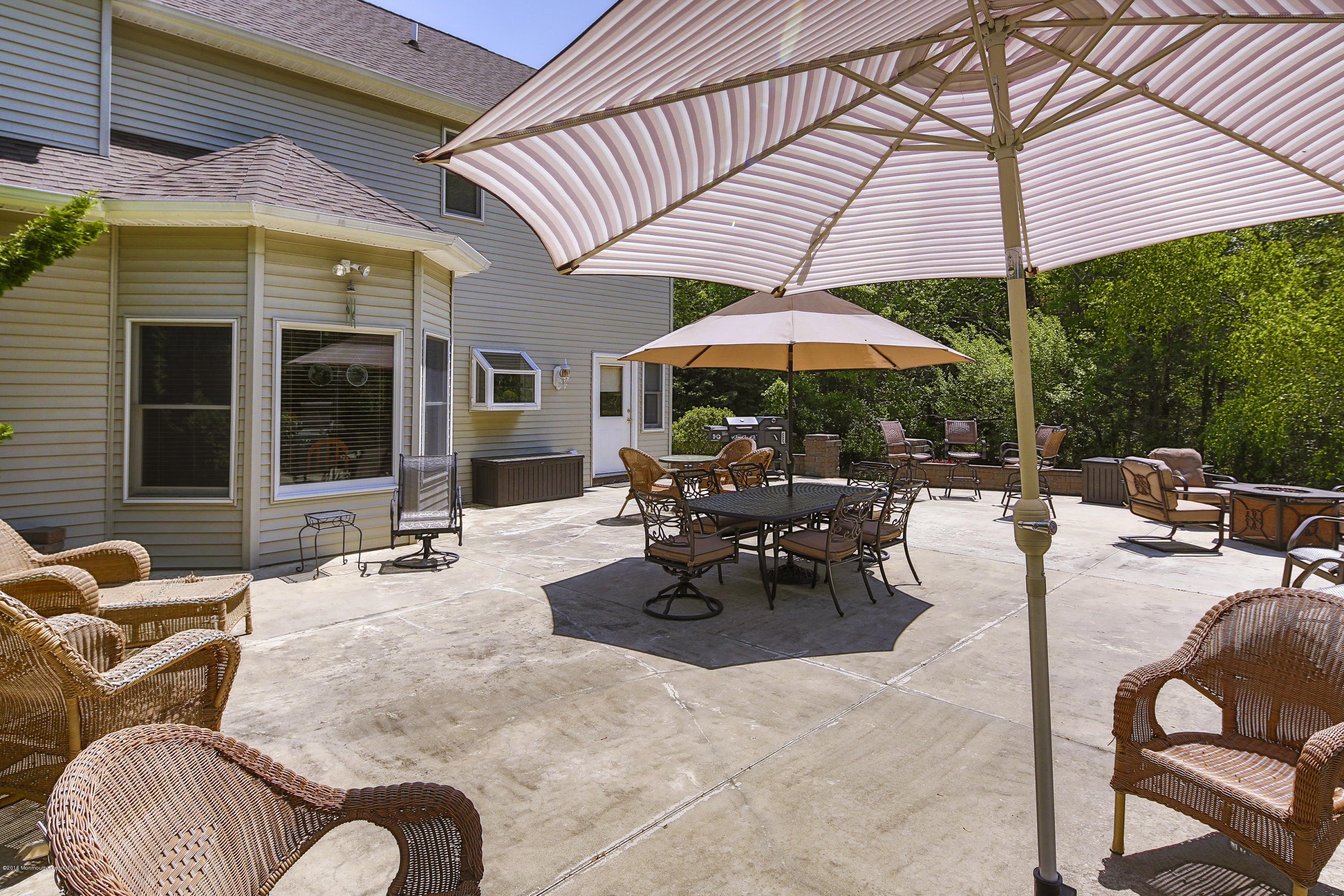 55 Spring Road Clarksburg, NJ 08510 - Photo 36 of 44 a view of a patio with dining table and chairs under an umbrella