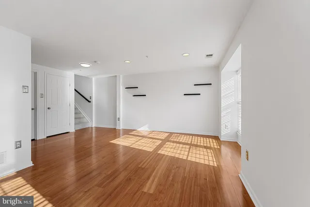 a view of an empty room with wooden floor