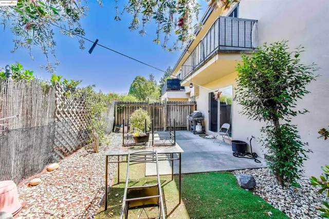 a backyard of a house with table and chairs plants
