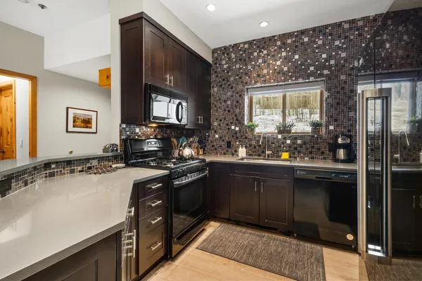 a kitchen with stainless steel appliances granite countertop a sink stove and cabinets