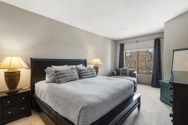 a bedroom with a bed a large window and tv