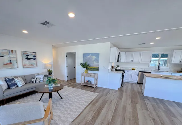 a kitchen with a sink a stove a refrigerator a center island and a cabinets