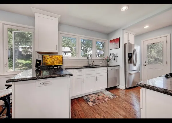 a large kitchen with stainless steel appliances granite countertop a stove and a sink
