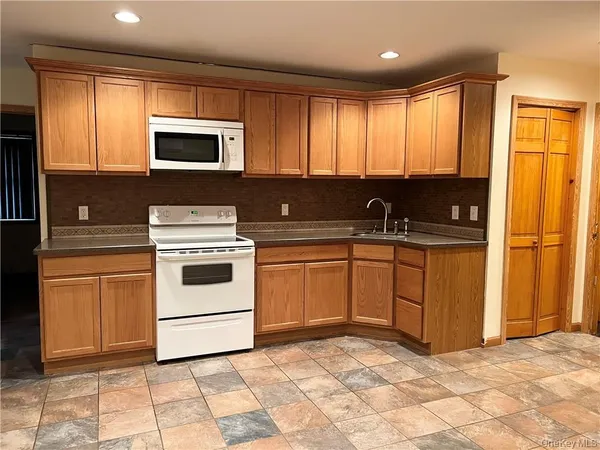 a kitchen with stainless steel appliances granite countertop a stove a sink and a microwave