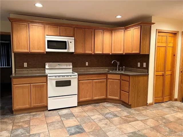 a kitchen with stainless steel appliances granite countertop a stove a sink and a microwave