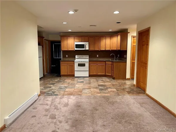 a large kitchen with stainless steel appliances granite countertop a refrigerator and a stove top oven