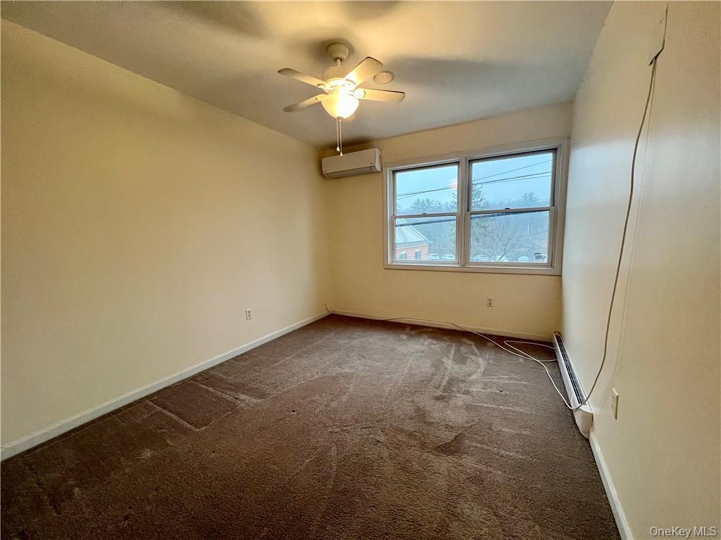 26 Wallkill Avenue, Unit 2 Wallkill, NY 12589 - Photo 9 of 13 an empty room with a chandelier fan and windows