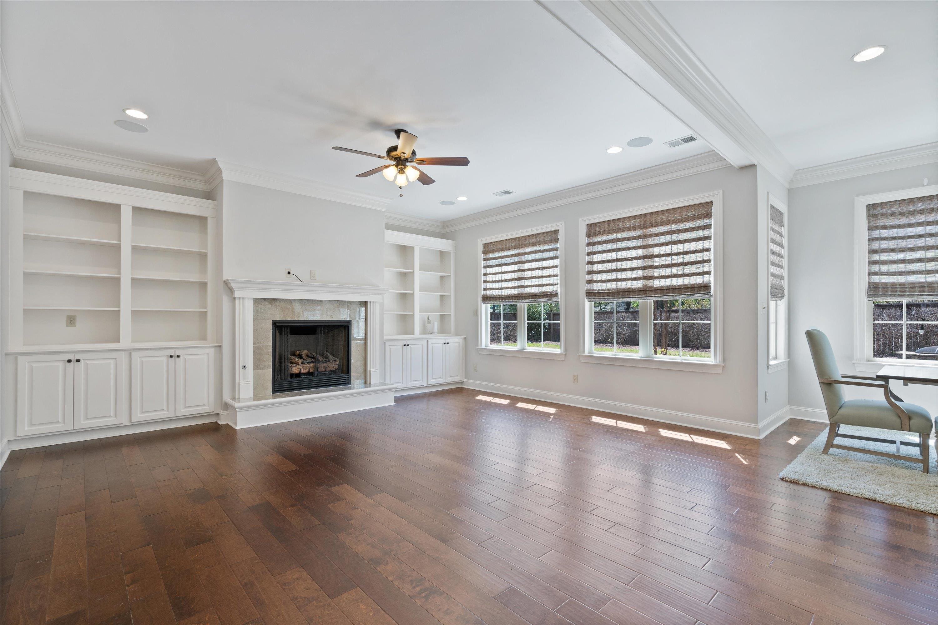 5168 Barry Road Memphis, TN 38117 - Photo 6 of 25 an empty room with windows fireplace and wooden floor