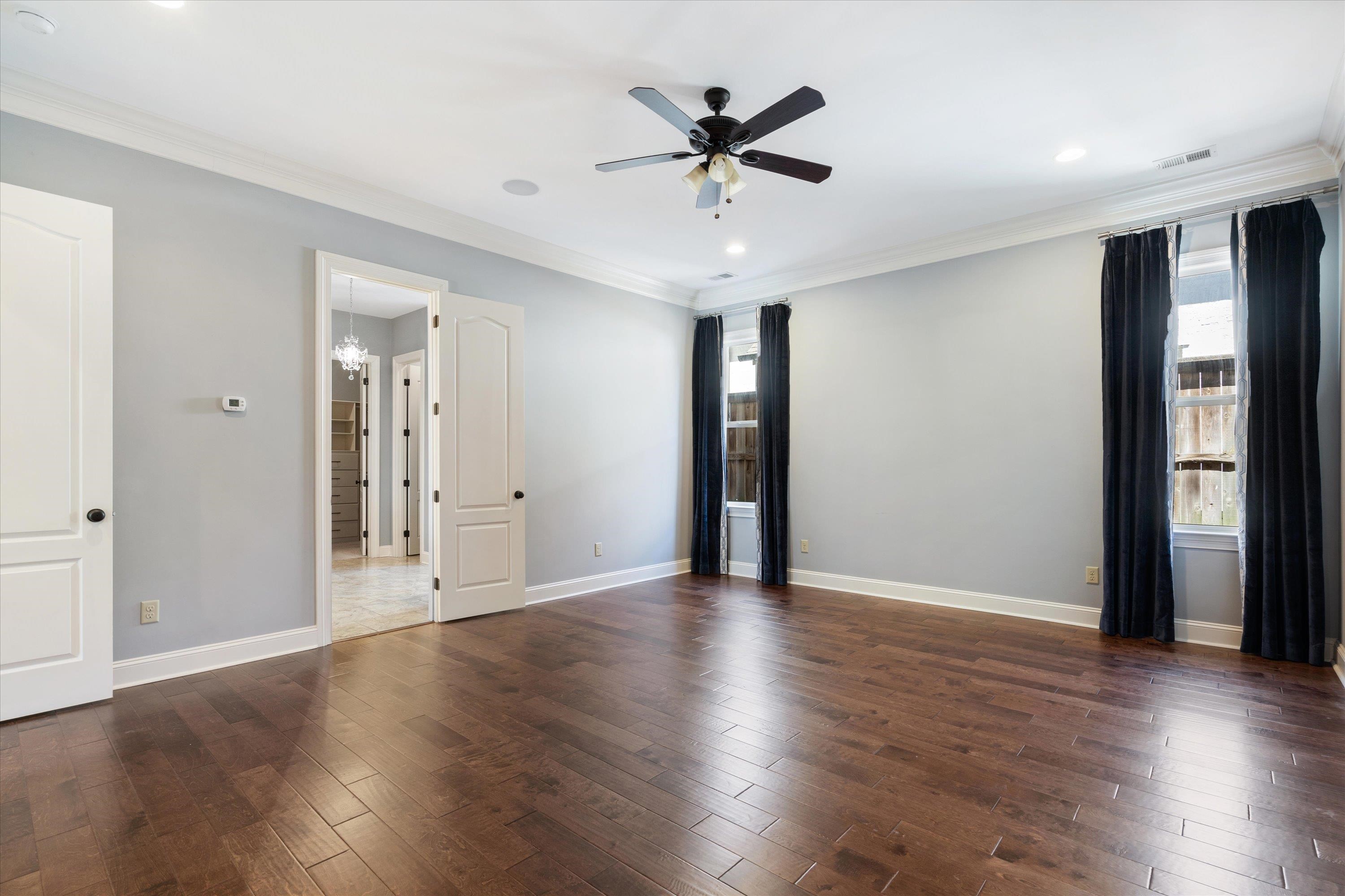 5168 Barry Road Memphis, TN 38117 - Photo 7 of 25 a view of an empty room with wooden floor and a ceiling fan
