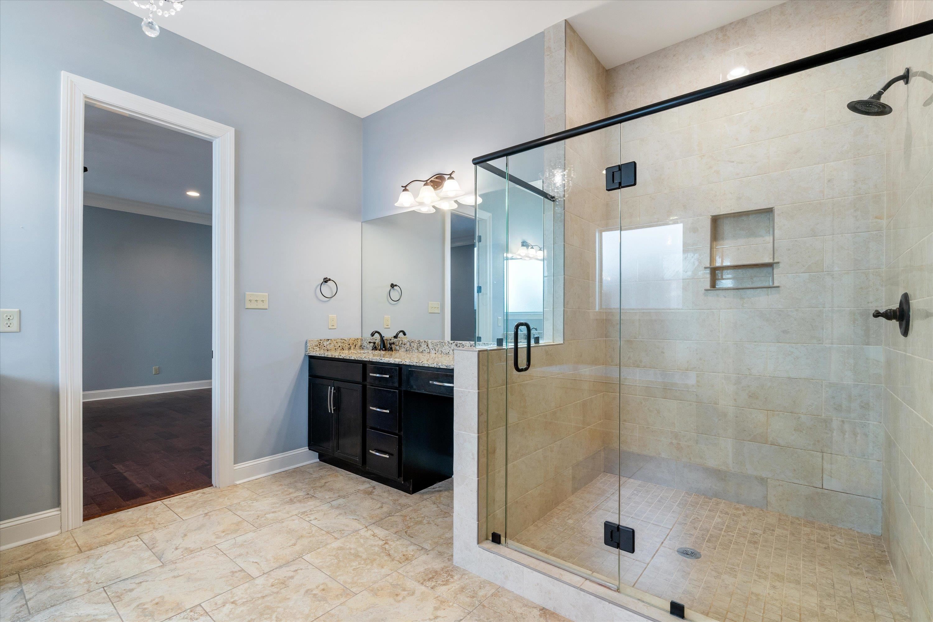 5168 Barry Road Memphis, TN 38117 - Photo 8 of 25 a bathroom with a glass shower door and a sink