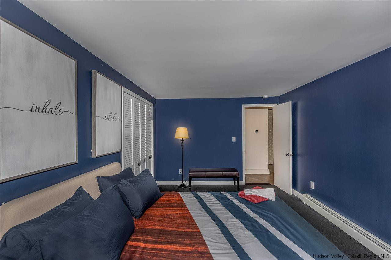 96 Lake Road Hunter, NY 12442 - Photo 18 of 35 a spacious bedroom with a bed and wooden floor