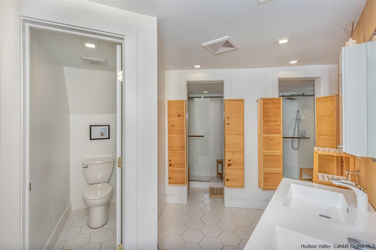96 Lake Road Hunter, NY 12442 - Photo 22 of 35 a bathroom with a granite countertop sink a toilet and shower