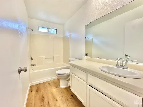 a bathroom with a sink a toilet and a large mirror