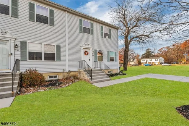 a view of a house with backyard and a tree