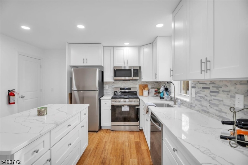 348 Silk Street Lawnside, NJ 08045 - Photo 5 of 24 a kitchen with cabinets a sink and stainless steel appliances