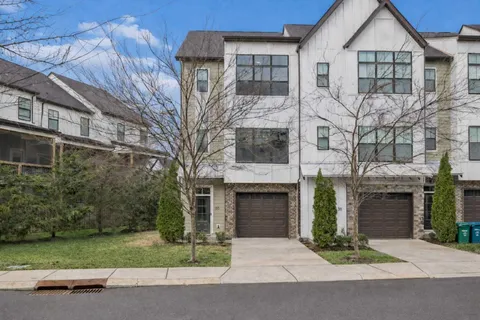 a front view of a house with yard and parking