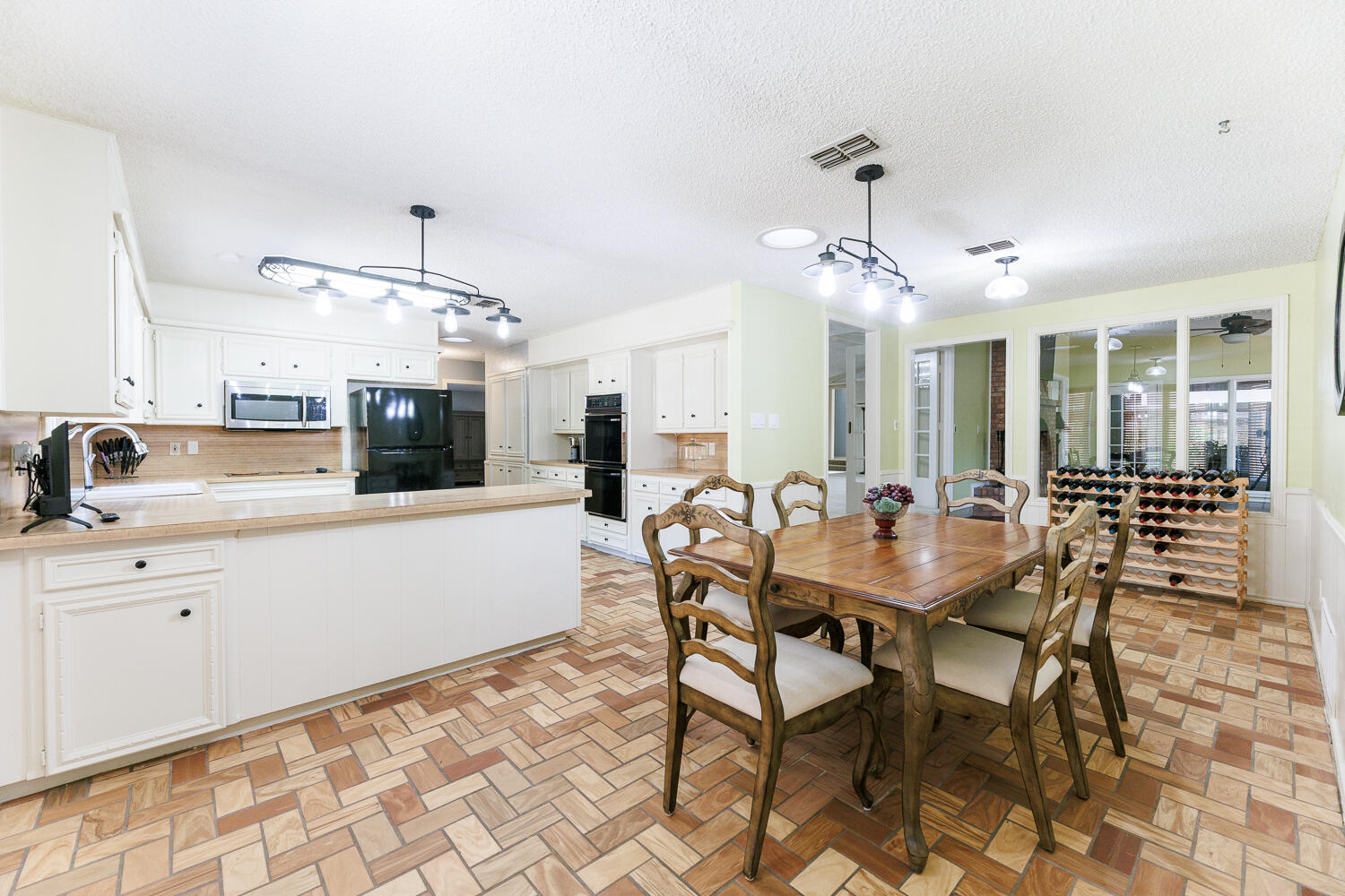 3713 95th Street Lubbock, TX 79423 - Photo 17 of 70 a kitchen with a dining table chairs and white cabinets