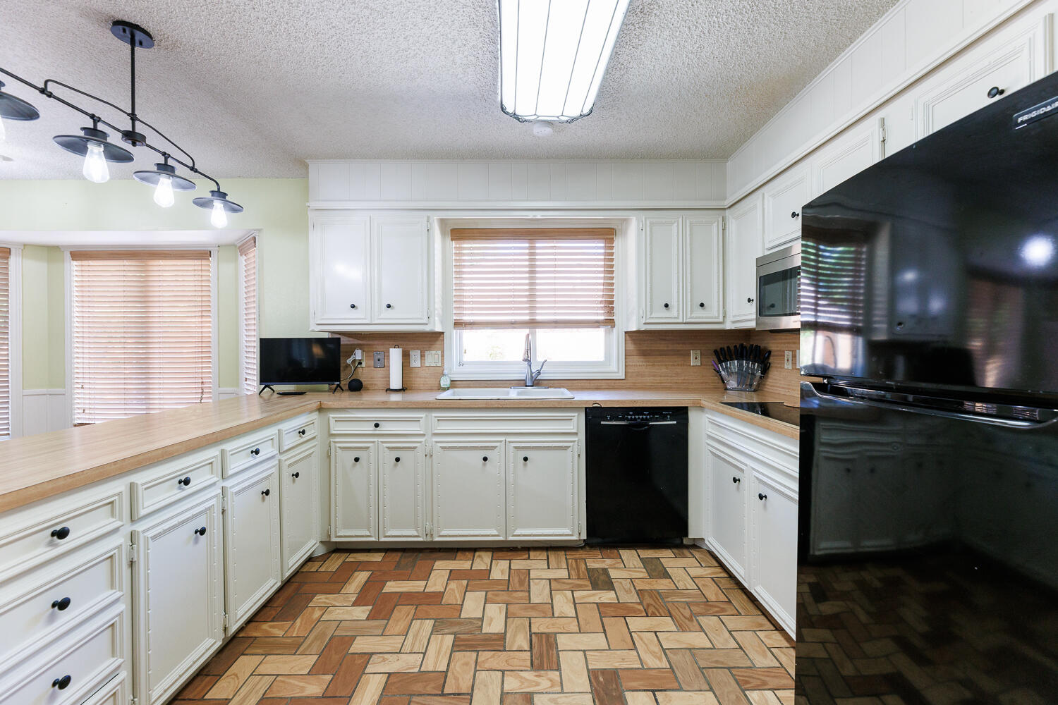 3713 95th Street Lubbock, TX 79423 - Photo 20 of 70 a kitchen with a sink window and cabinets