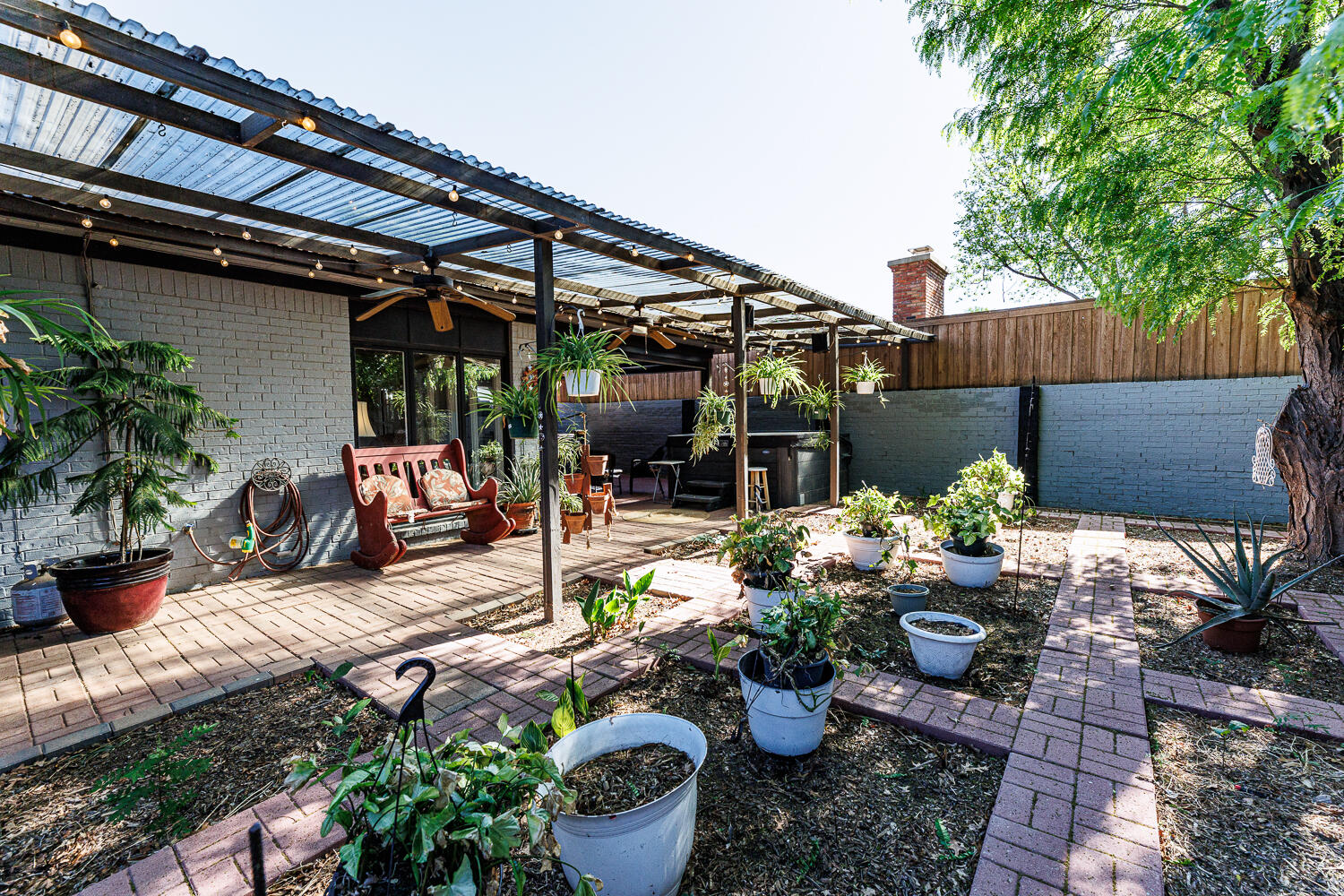 3713 95th Street Lubbock, TX 79423 - Photo 67 of 70 a view of a patio with table and chairs potted plants and wooden fence