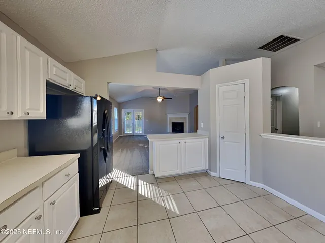 a kitchen with cabinets and chairs