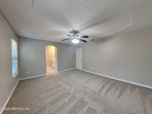 a view of a livingroom with a ceiling fan and window