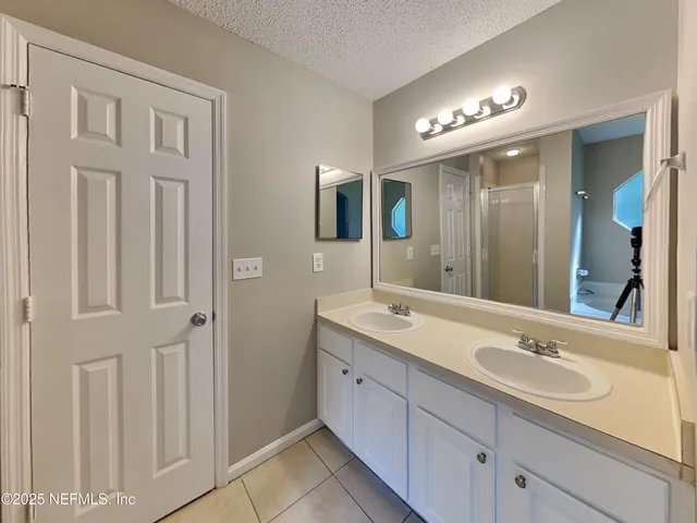 a bathroom with a double vanity sink and a mirror