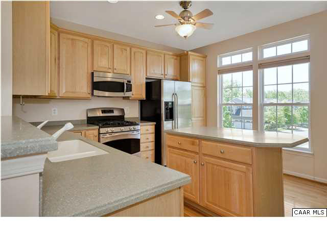 803 Rainier Road Charlottesville, VA 22903 - Photo 4 of 22 a kitchen with stainless steel appliances kitchen island granite countertop a refrigerator oven a sink dishwasher a stove and white countertops with wooden floor