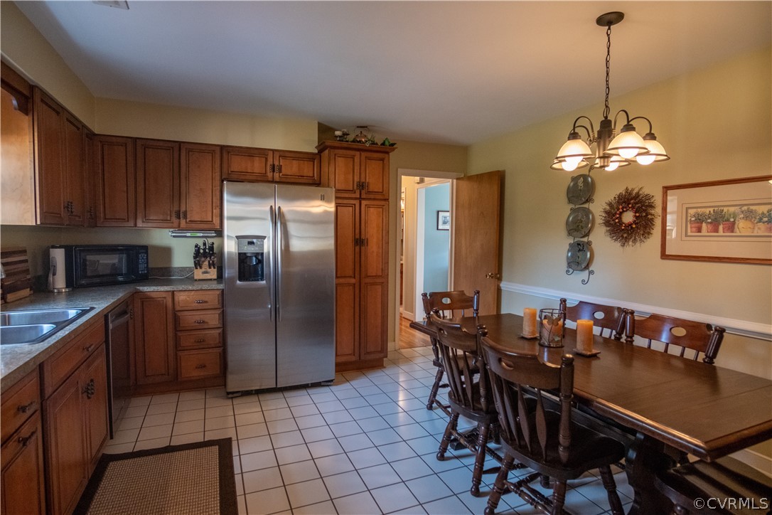 11500 Davelayne Road Midlothian, VA 23112 - Photo 6 of 23 a kitchen with stainless steel appliances granite countertop a dining table chairs and a refrigerator