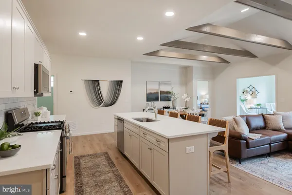 a kitchen with a stove a sink a microwave a refrigerator and cabinets