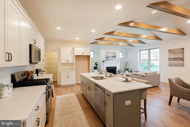a kitchen that has a sink a stove and chairs
