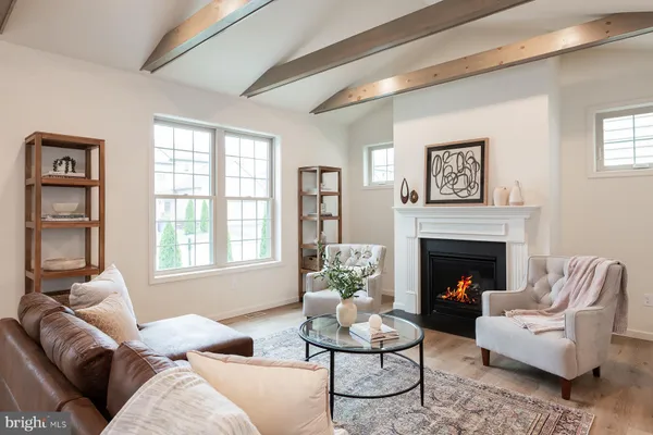 a living room with furniture white walls and kitchen view