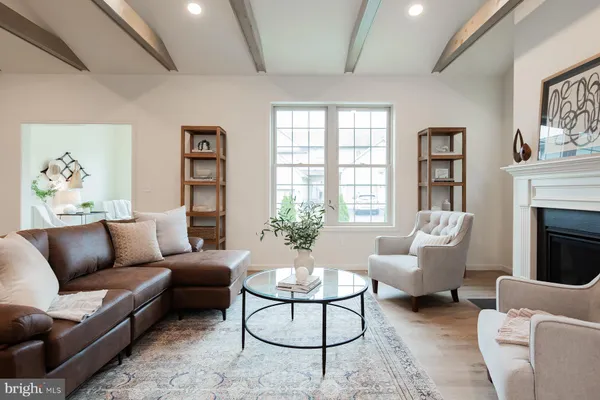 a living room with furniture fireplace and a large window