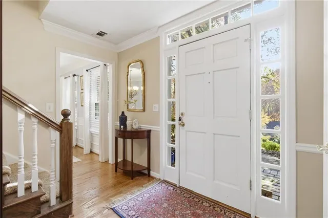 a view of a hallway with wooden floor and a bathroom