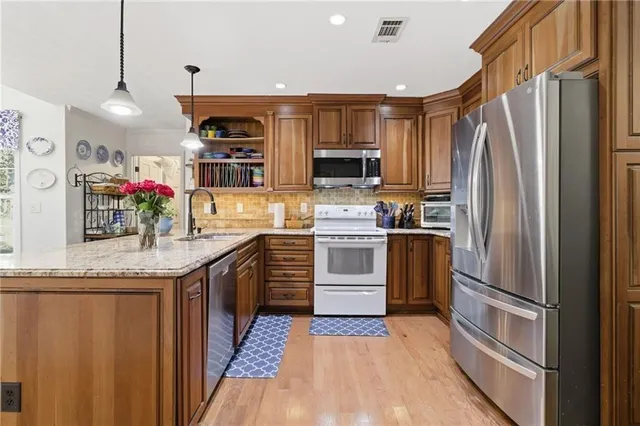a kitchen with granite countertop a refrigerator stove top oven and sink