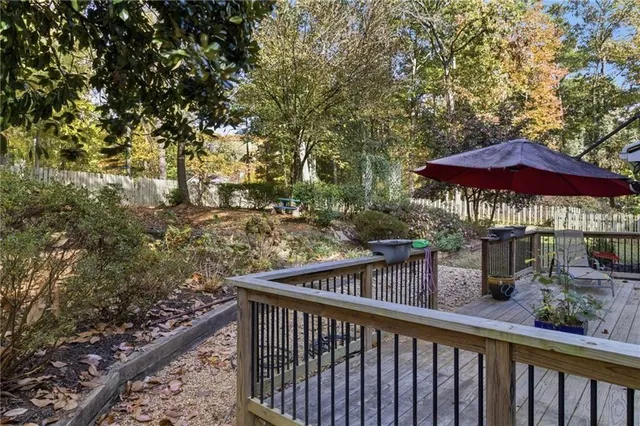 a view of a wooden deck with chairs under an umbrella