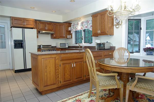 87 Hobart Road Newton, MA 02459 - Photo 11 of 22 a kitchen with kitchen island granite countertop a stove top oven a sink a counter space and cabinets