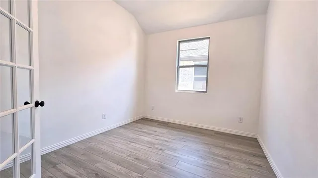 a view of a kitchen with wooden floor and a window