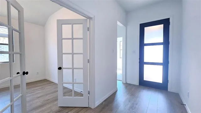 an empty room with wooden floor and window