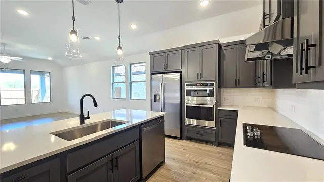a kitchen with kitchen island a sink stainless steel appliances and window