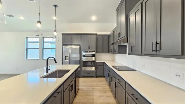 a kitchen with stainless steel appliances a sink a stove and a center island