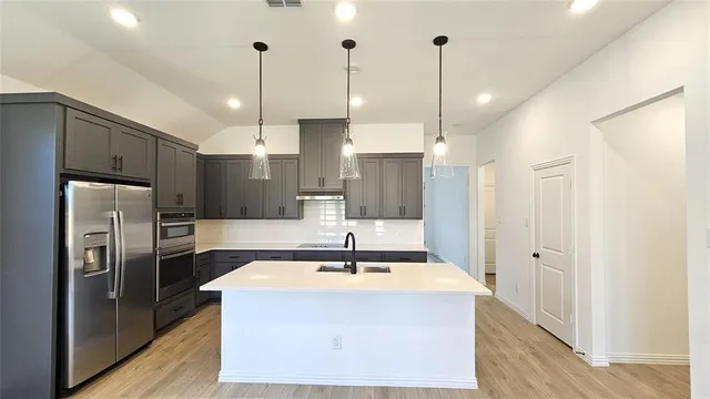 a kitchen with stainless steel appliances a refrigerator sink and microwave