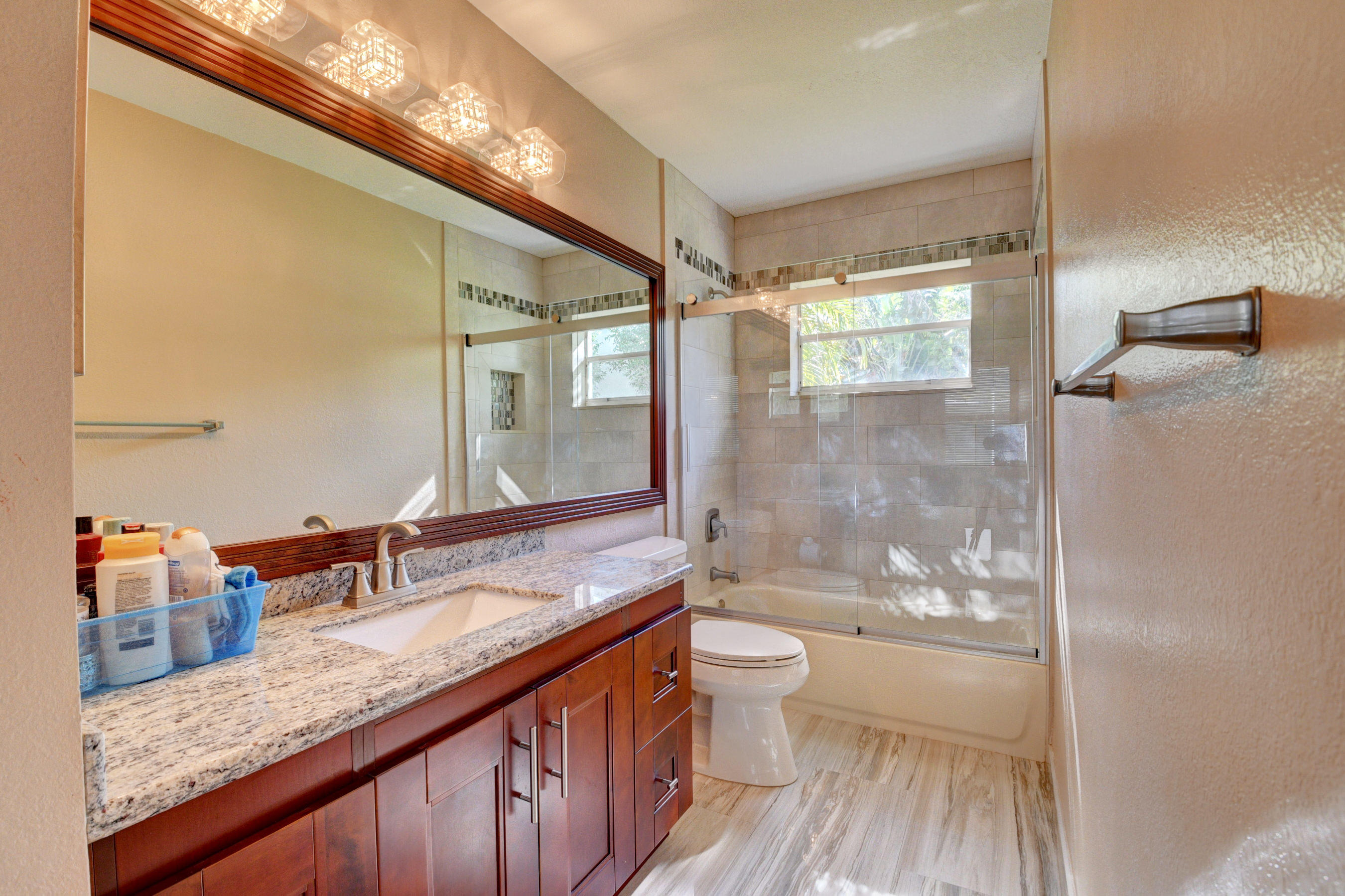 12059 Rockwell Way Boca Raton, FL 33428 - Photo 21 of 28 a bathroom with a granite countertop sink a toilet a mirror and shower