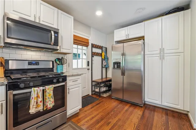 a kitchen with stainless steel appliances granite countertop a stove a refrigerator and a microwave