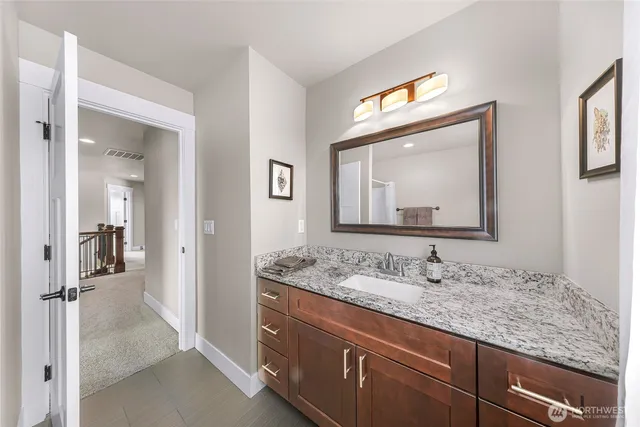 a bathroom with a granite countertop sink mirror and vanity