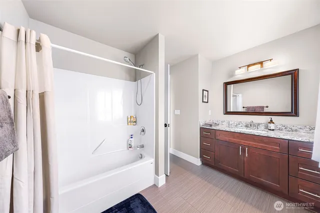 a bathroom with a tub sink and mirror