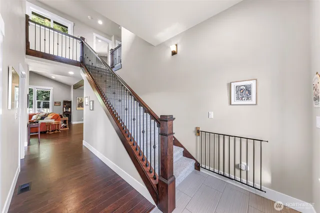 a view of a hallway with wooden floor and stairs
