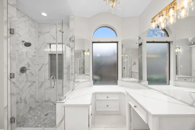 a bathroom with a double vanity sink mirror and shower
