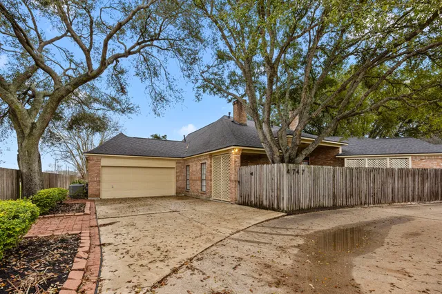 a front view of a house with a large tree