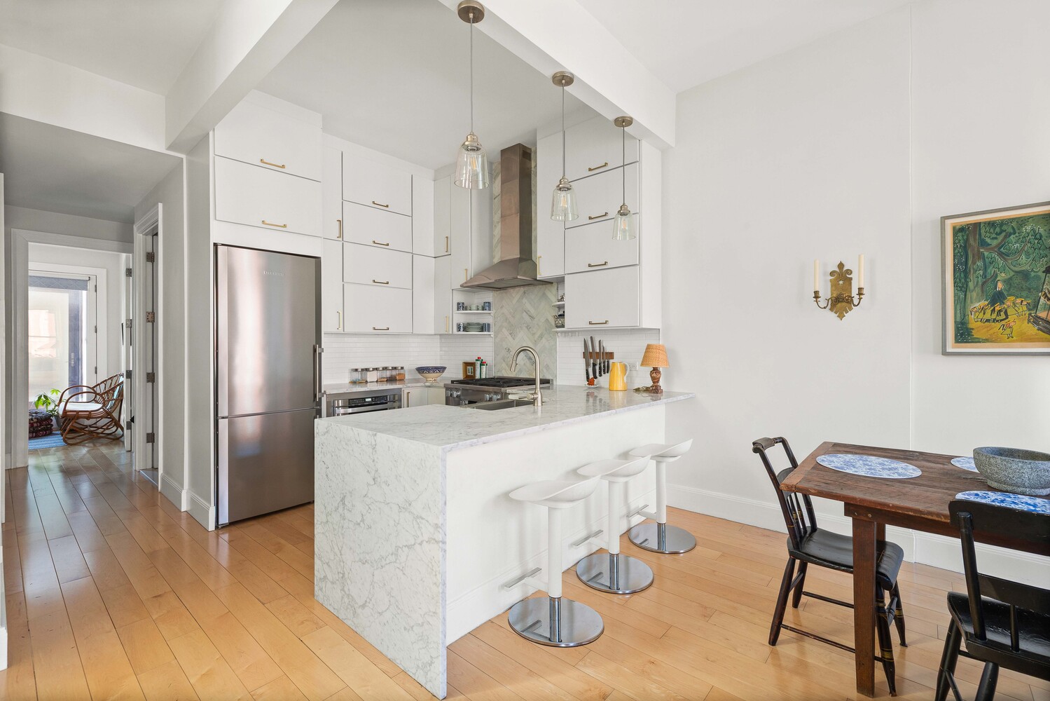 541 Henry Street, Unit D Brooklyn, NY 11231 - Photo 3 of 11 a kitchen with stainless steel appliances kitchen island a table chairs and wooden floor